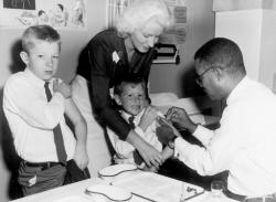 PHOTO COURTESY OF DORN&rsquo;S CLASSIC COLLECTION Parker administers a smallpox inoculation to a child at a clinic in 1963.  