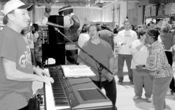 CHRIS KELLY staff (Above) Matthew Felis (l), Fair Haven, Michael McGrath, Hazlet, and Aishah Saeed, Farmingdale, dance while Tim McLoone, founder of Holiday Express, supplies the music at a holiday party for clients of Monmouth Center for Vocational Rehabilitation in Eatontown. (Photo left) A troupe of more than 200 volunteers helped stage close to 50 parties this holiday season. 