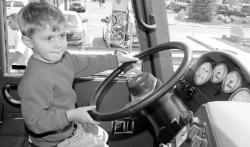 CHRIS KELLY staff Jack Friedman, 3, Long Branch, pretends he is driving one of the Sea Bright Fire Department's fire trucks during the borough's 125th anniversary celebration on May 20. Below, Allen Kniffin, 10, of Sandy Hook, swings for a high pitch during a game of beach baseball during the festivities.