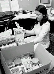 JEFF HUNTLEY  Sentinel reporter Nicole Vaccaro sorts through all of the items sent for the children of the isiZulu container school in South Africa. A care package filled with readers&rsquo; generous contributions will be sent later this week. 