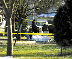 Members of the Middlesex County Coroner&rsquo;s Office remove the body of Edward Abrams Jr. near Eastern Street and Vargas Park last week. Abrams was gunned down by police after he allegedly shot two police officers and two civilians in the area. 