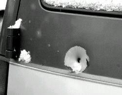 PHOTOS BY JEFF HUNTLEY South River Detective John Casey takes photographs of a vehicle struck by several bullets during a shooting spree on William Street in the borough last week. A bullet hole (inset) in a South River resident&rsquo;s car is damage allegedly caused by Edward Abrams Jr. last week. 