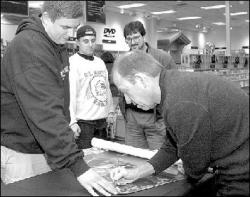 VERONICA YANKOWSKI Danny Federici signs a poster for Marc Szuba, Middlesex, at Border&rsquo;s Books & Music, Route 18 in East Brunswick, on Dec. 3.