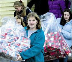 JERRY WOLKOWITZ Christine Cox (front) and Christy Fic (right), both 13, carry gifts to be distributed to needy families through the South River Middle School PTA&rsquo;s Adopt-a-Family program last week.