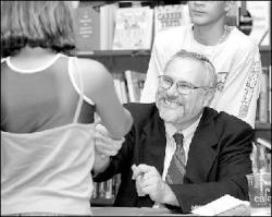 JERRY WOLKOWITZ Rabbi Benjamin Levy of the Monroe Jewish Center shakes hands with a young reader during a book signing Tuesday at Border&rsquo;s in East Brunswick.