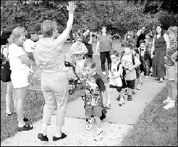 DAWNMARIE SANNWALDT  Milltown kindergarten teacher Patty Pellichero (above) waves goodbye to parents as her class arrives at Parkview School for the first day Wednesday morning. At right, Chris Raymond, the new principal at East Brunswick&rsquo;s Lawrence Brook School, speaks with parent Maria Ferguson (on left) during a bagel breakfast held during the first day of school Wednesday morning.