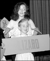 FARRAH MAFFAI Second-grader Grant Newbold mimics a lizard during a presentation from Flumpa Live! with &ldquo;singing scientist&rdquo; Wendy Whitten. Whitten and the Flumpa cast taught students at Corpus Christi School, South River, about amphibians and other creatures of the rain forest on Sept. 19.