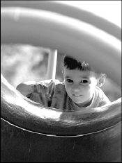 FARRAH MAFFAI Justin Najiman, 2, of East Brunswick, peers through a slide before taking a ride during a recent visit to Bicentennial Park in East Brunswick.