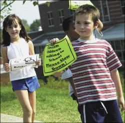 FARRAH MAFFAI Damion Esposito holds a reminder for drivers while walking with fellow second-graders at the South River Elementary School during National Walk Our Children to School Day Oct. 2. Story, page 34.