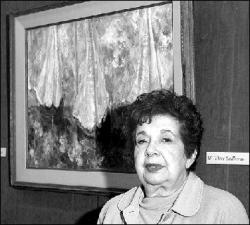 Rose Balsamides Sakel of East Brunswick talks about her works, including Three Sailboats, an oil painting on display at the township&rsquo;s library. Glorious Flora (at right) is another oil painting being exhibited.  PHOTOS BY JERRY WOLKOWITZ