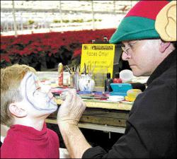 FARRAH MAFFAI Nicholas Zrebiec, 6, of Jackson, has his face painted by &ldquo;Elf&rdquo; Dennis Pettar during a holiday event at Gasko&rsquo;s Family Farm Market in Monroe Township on Saturday.