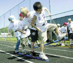 FARRAH MAFFAI David Ramirez, 9, at right, leads Francis Renner, 8, Adam Gerhart, 9, and Emily Oberst, 9, in the team ski relay during Fun Day at South River Elementary School Friday.