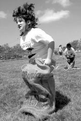 Lauren Heitz, 8, bounds up and down the playground in a potato sack race during Fun Day.