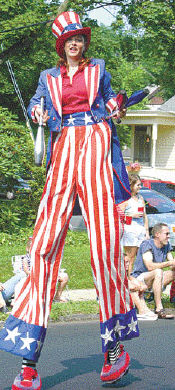 STEVEN M. BARON A juggler on stilts marches in the parade.