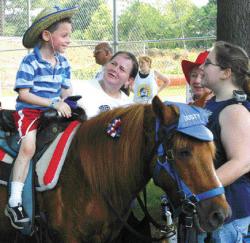 STEVEN M. BARON Noah Wolack, 4, of South River enjoys a pony ride on Dusty following the parade in Milltown.