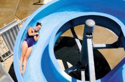 JEFF GRANIT The recent hot, sunny weather has made community swimming pools a popular afternoon           destination. Here, Megan Coy glides down the waterslide at the Milltown swimming pool Tuesday.