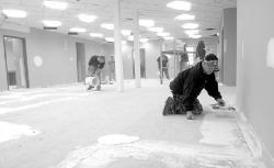 JEFF GRANIT staff Workers apply leveling compound to the South River municipal building floor Tuesday.