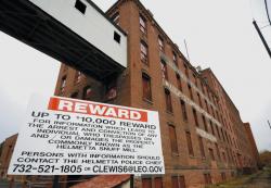JEFF GRANIT staff A sign posted by Kaplan Cos., owner of the former Helme Tobacco Co. site, advertises a reward for information leading to the arrest of trespassers on the property. Officials said there has been a problem with people entering the building and causing damage. 
