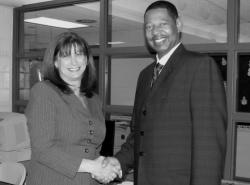 Monroe Board of Education President Amy Antelis shakes hands with Kenneth Hamilton last week after he was appointed the district's new superintendent of schools. 
