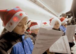JEFF GRANIT staff Jamesburg's tree lighting and holiday concert went on as planned at Veterans Park, despite the rain and wind Dec. 10. Here, Joshua Pemberton, 7, sings holiday songs with other borough youngsters under the cover of a roof on a portable stage. 