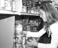 CHRIS KELLY staff Red Bank Middle School student Mary McMahon, 13, stocks donated food onto shelves at Lunch Break, a soup kitchen in Red Bank.