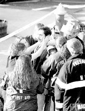 Emergency personnel (above) attend to an employee of The Busy BBB&rsquo;s who was inside the flower shop when an SUV crashed into the store after colliding with a  locomotive at West Main and Throckmorton streets in Freehold Borough late Monday afternoon. JERRY WOLKOWITZ 
