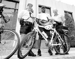  Freehold Borough patrolmen Mark Wodell (l) and Maurice Parrish, members of the department&rsquo;s bicycle patrol, chat with Chuck Hearn, plant manager of Nestle Food Corp., during a visit to the firm&rsquo;s headquarters on Jerseyville Avenue. For the second year in a row, Nestle has presented the police department&rsquo;s community patrol with $1,000 to be used toward the purchase of new bicycles. 