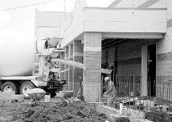 JERRY WOLKOWITZ  Construction workers renovate the exterior of the former Builder&rsquo;s Square store at Freehold Raceway Mall in preparation for its reopening as a Home Depot. Store officials anticipate a late August opening. 