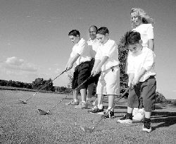 JERRY WOLKOWITZ Chuck and Gina DiLeo, of Manalapan, watch as their sons Vincent, 12, Patrick, 9, and Johnny, 4, practice their golf swings at Knob Hill Golf Course in Manalapan on Friday. The DiLeos operate the Junior Golf Competition Association of New Jersey. 