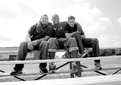 JERRY WOLKOWITZ Darrell Reid (center) puts a bear hug around his fellow athletes of the year Dave O&rsquo;Rourke (l) and Jason Kutney. The three star athletes all graduated from Freehold High School this year. 