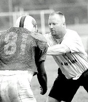 JERRY WOLKOWITZ Colts Neck High School head coach Mike McArthur shows proper blocking technique during a recent practice. 