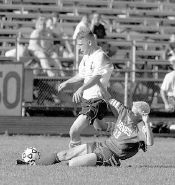 JERRY WOLKOWITZ Manalapan&rsquo;s Rob Hanlon slides to knock the ball away from Howell&rsquo;s Brian Guilfoyle during last Wednesday&rsquo;s game. 