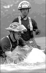 SARAH McCOLGAN  Andre Langlais, front, and Rich Meinsen, back, both of Manalapan, work           together during an event in the Fireman of the Woods Competition at Veterans Park, North Brunswick.