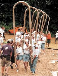 JERRY WOLKOWITZ Volunteers carry a swing set to its permanent spot at Liberty Street Park, Freehold Borough, during Saturday&rsquo;s KaBoom! playground construction project.