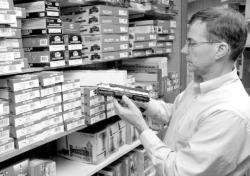 JERRY WOLKOWITZ staff  Jeff Carhart, owner of Model Railcraft Supply Depot, examines an HO scale locomotive from his inventory in his Red Bank shop.