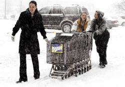 JERRY WOLKOWITZ staff Kristen Cizek and Jen Lopes (rear, l-r), both of Manalapan, push shopping carts through the parking lot at ShopRite, Marlboro, with the help of a co-worker as a snowstorm hits western Monmouth County on Jan. 22. More than a foot of snow eventually covered the region.